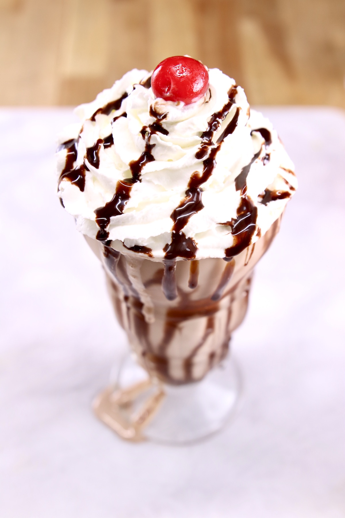 closeup of chocolate milkshake with a cherry on top