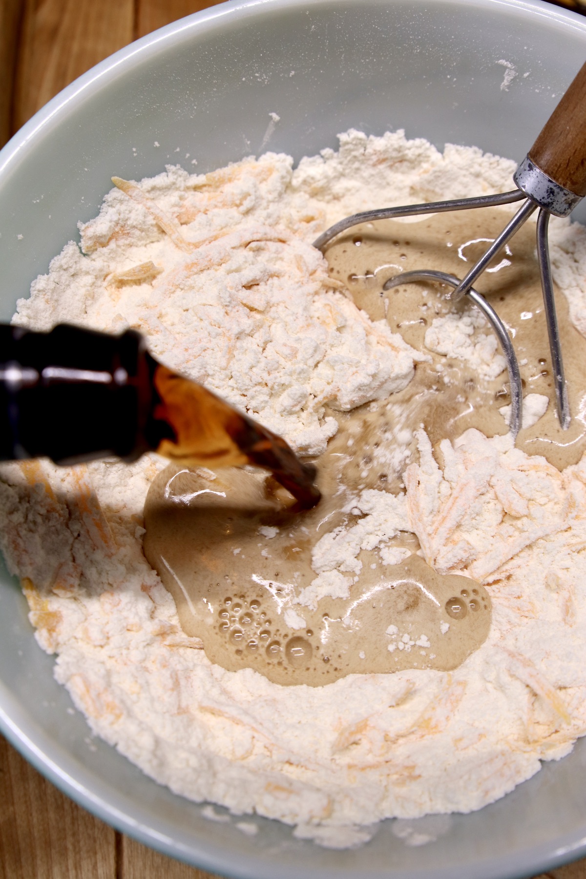 pouring beer into flour mixture in a bowl for bread