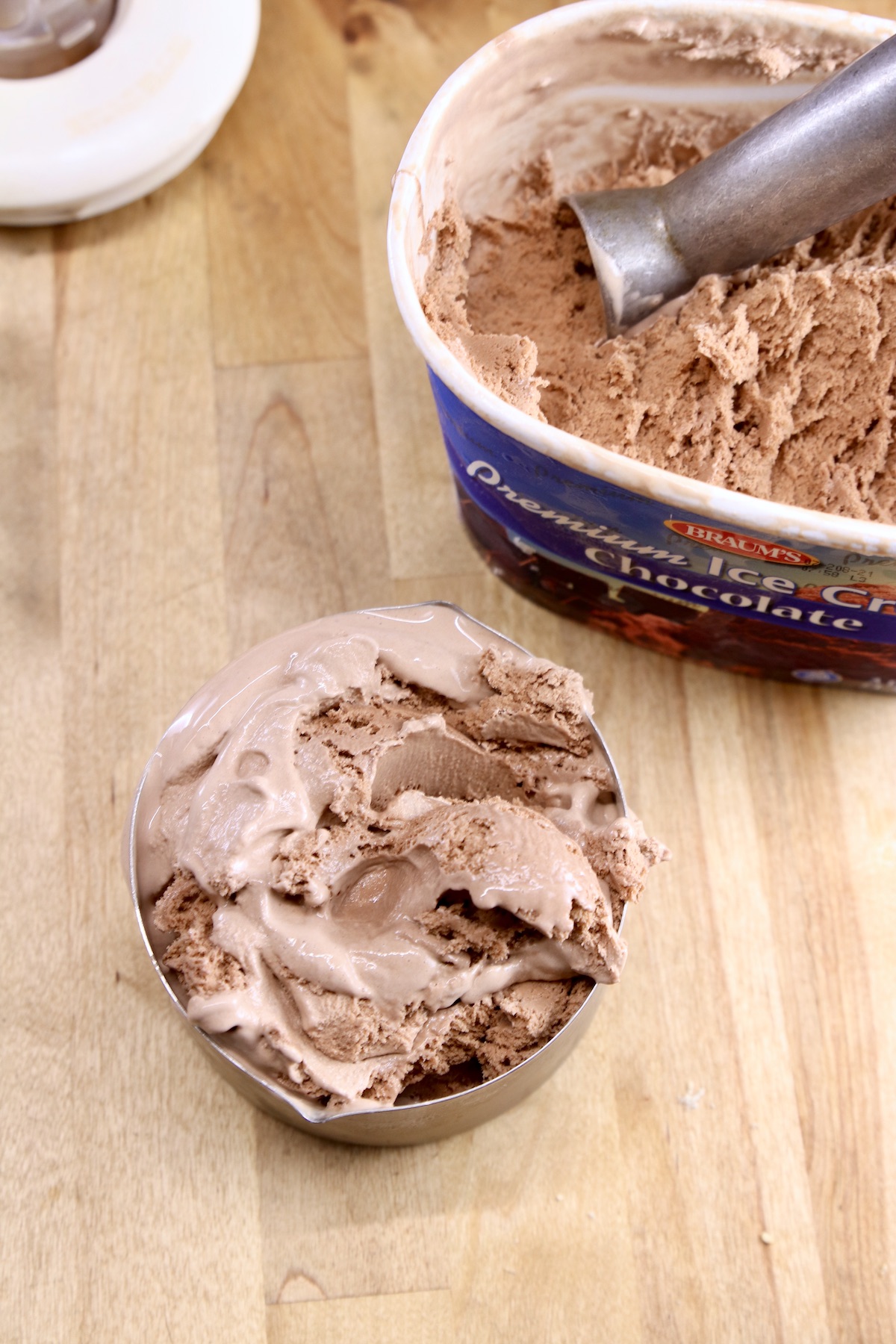 Chocolate ice cream in a measuring cup -scoop in ice cream container 