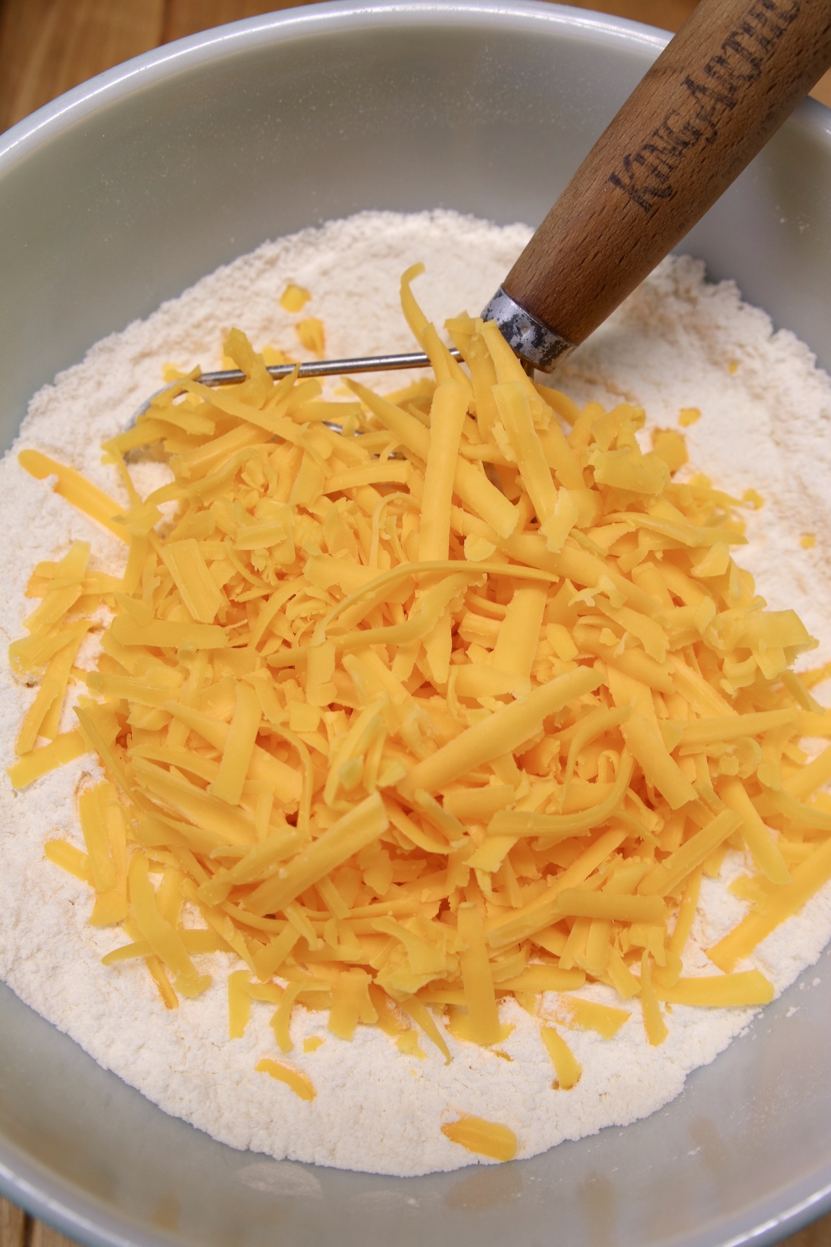 shredded cheese in a bowl with flour for beer bread