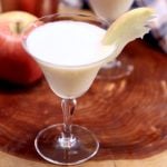 creamy caramel apple martini in a coupe glass with apple slice garnish