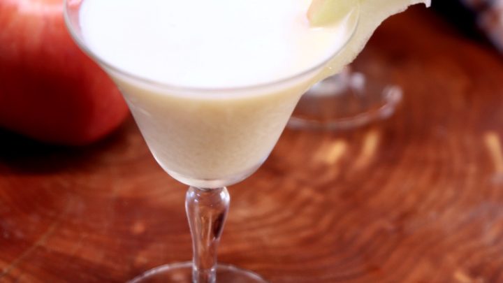 creamy caramel apple martini in a coupe glass with apple slice garnish