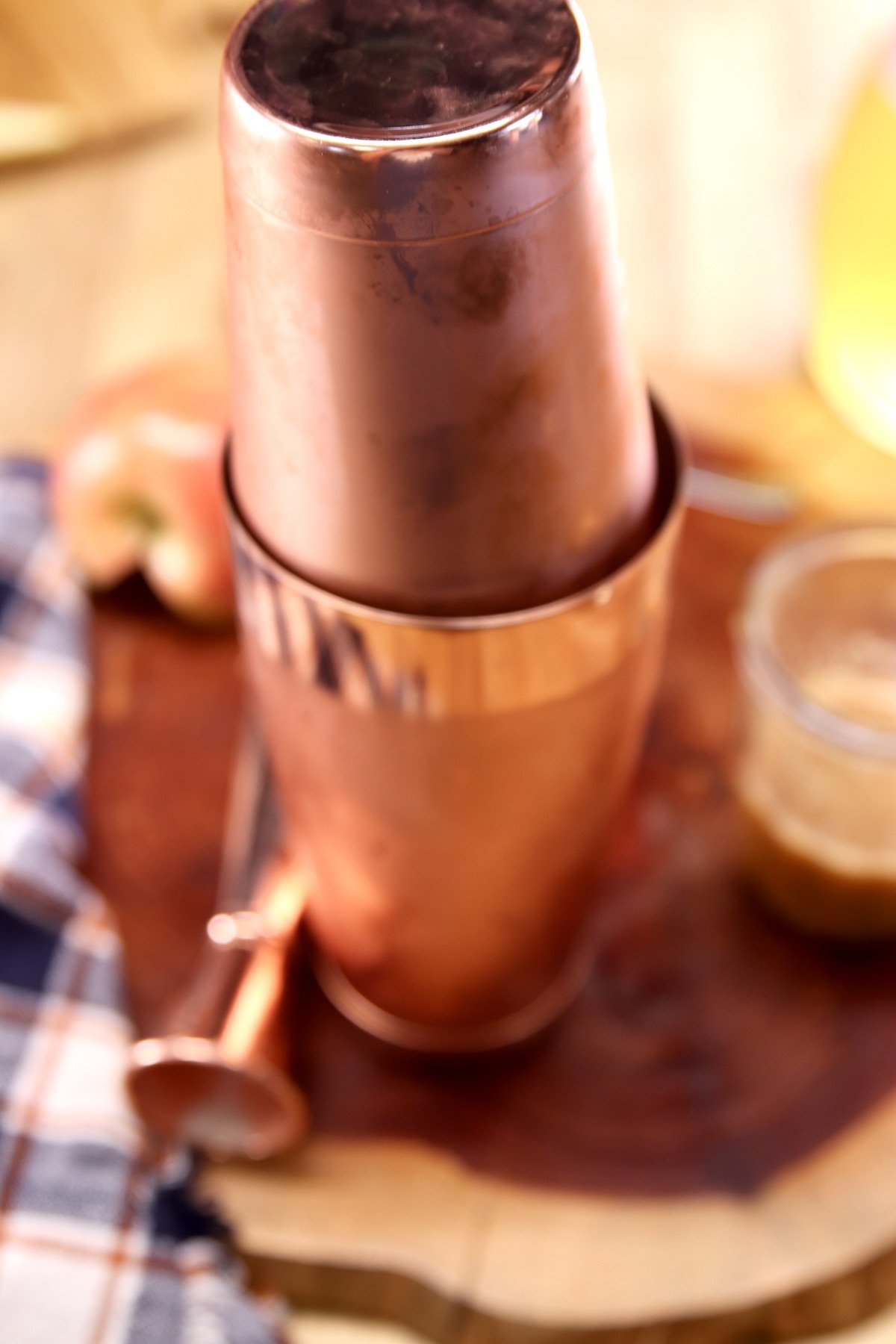 copper cocktail shaker on a wood board