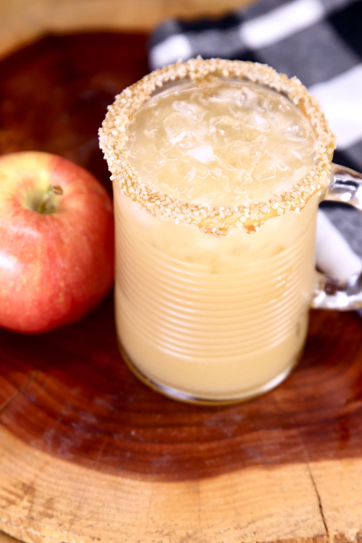 glass of caramel apple cocktail with apple to the side