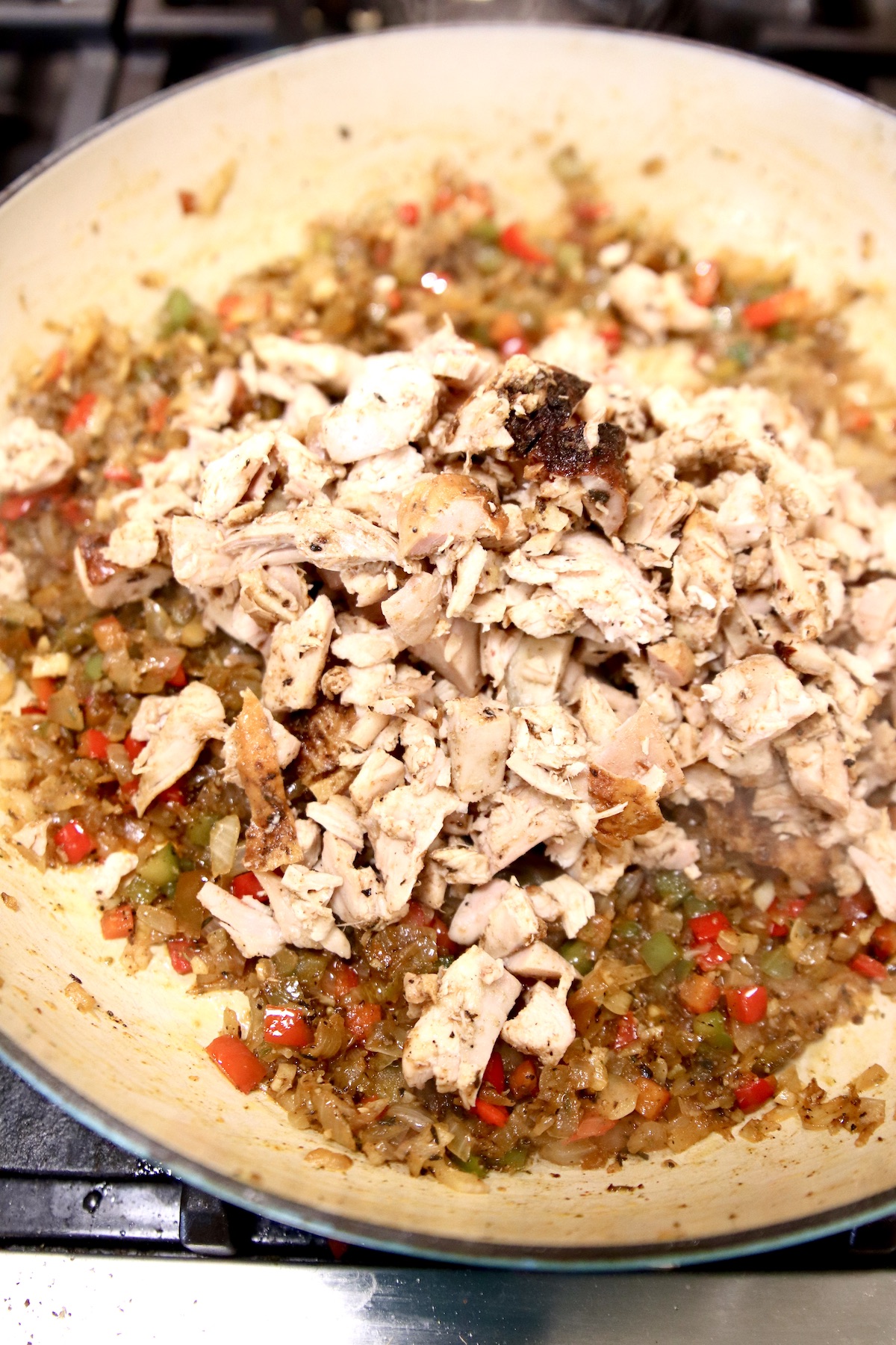 diced chicken added to skillet with peppers and onions