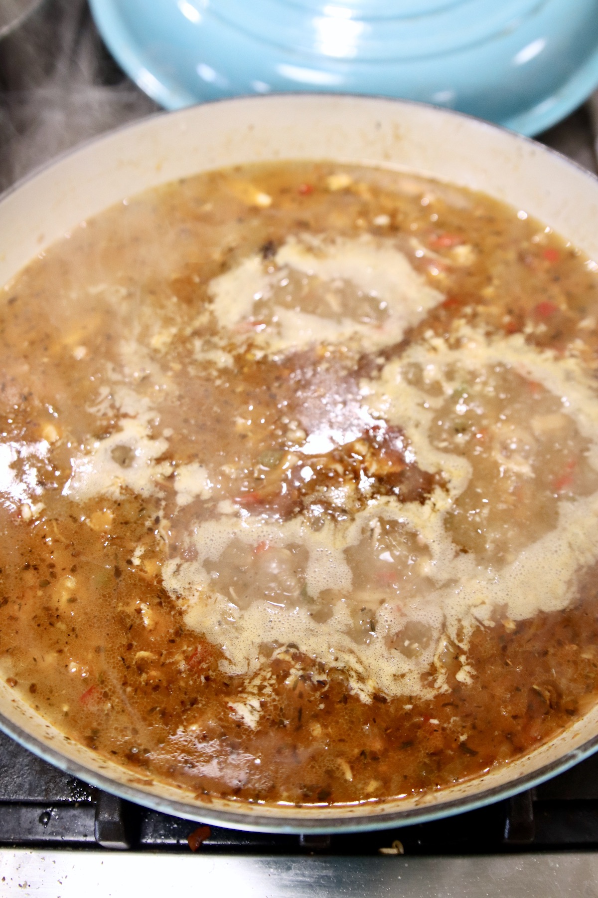 broth added to chicken and vegetables in a large skillet