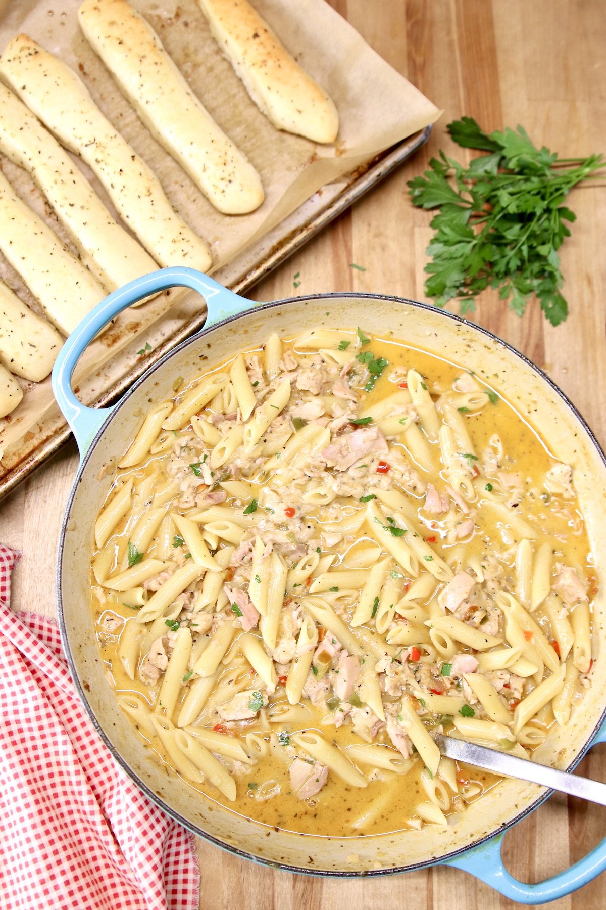 skillet of penne pasta with pan of breadsticks