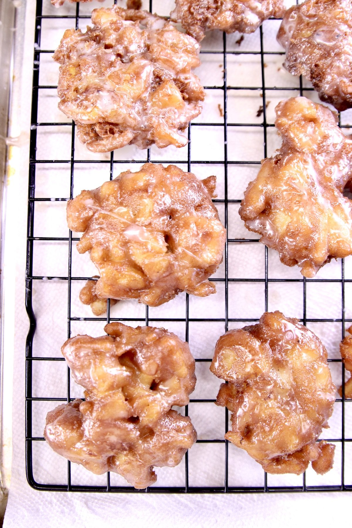 Glazed apple fritters on a wire rack