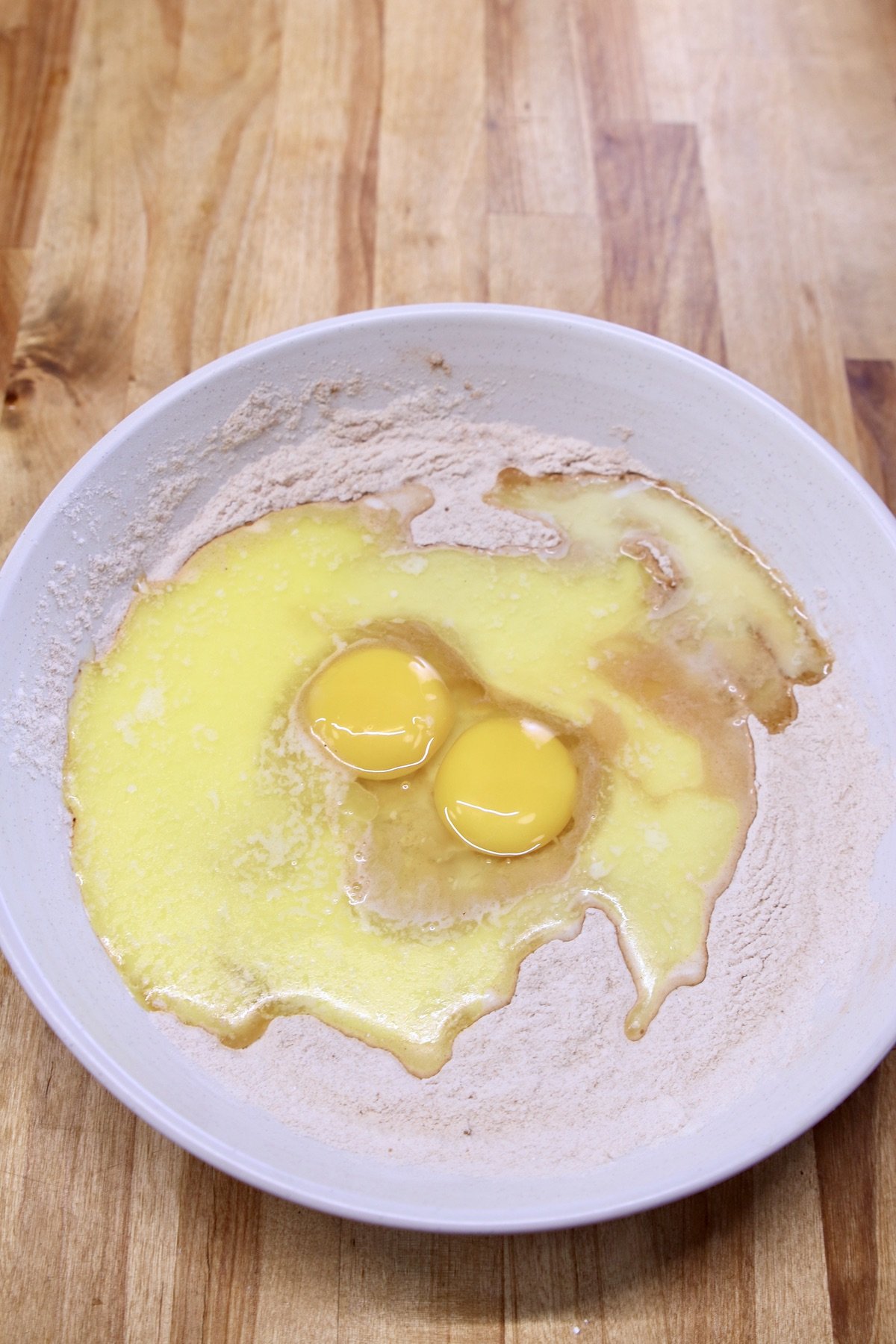 bowl with dry ingredients, eggs, butter, milk and vanilla