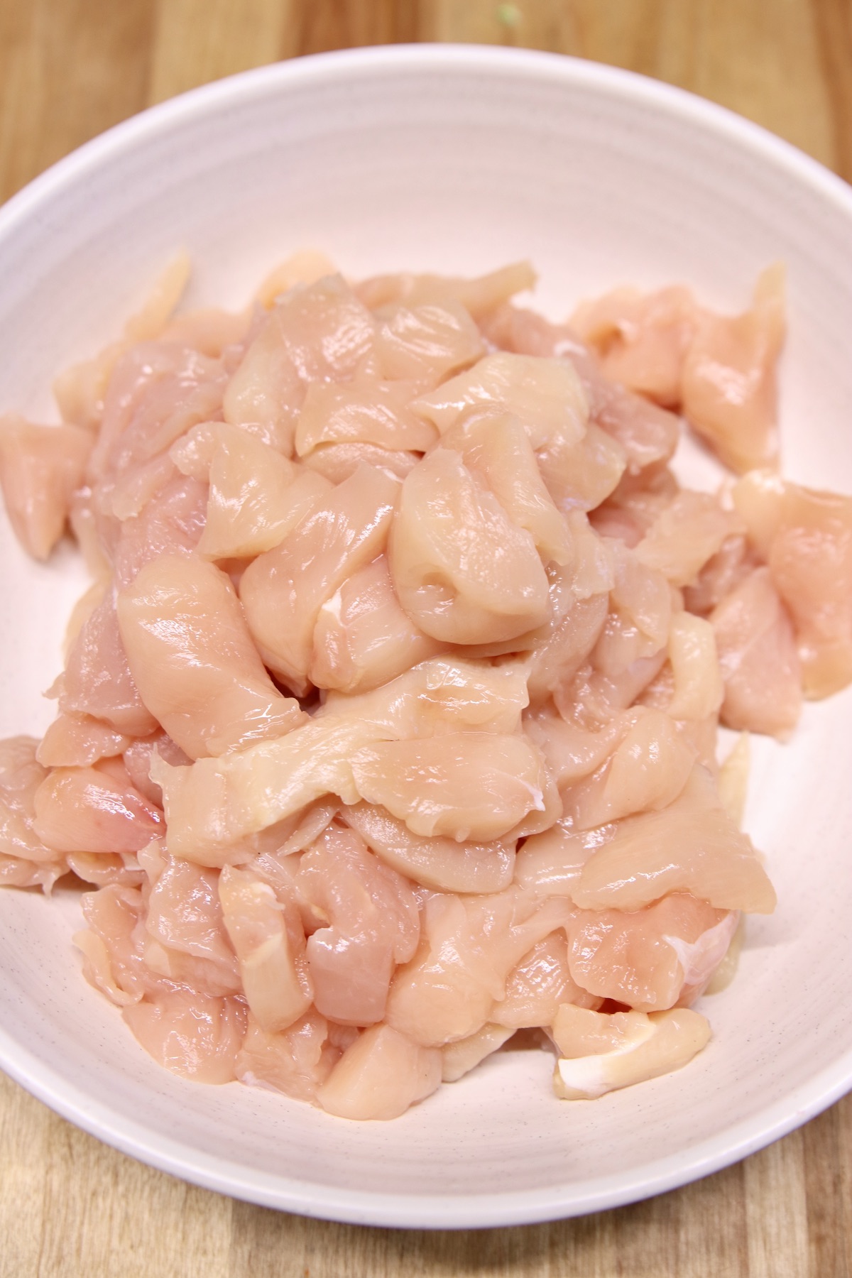 raw chicken cut into chunks in a bowl