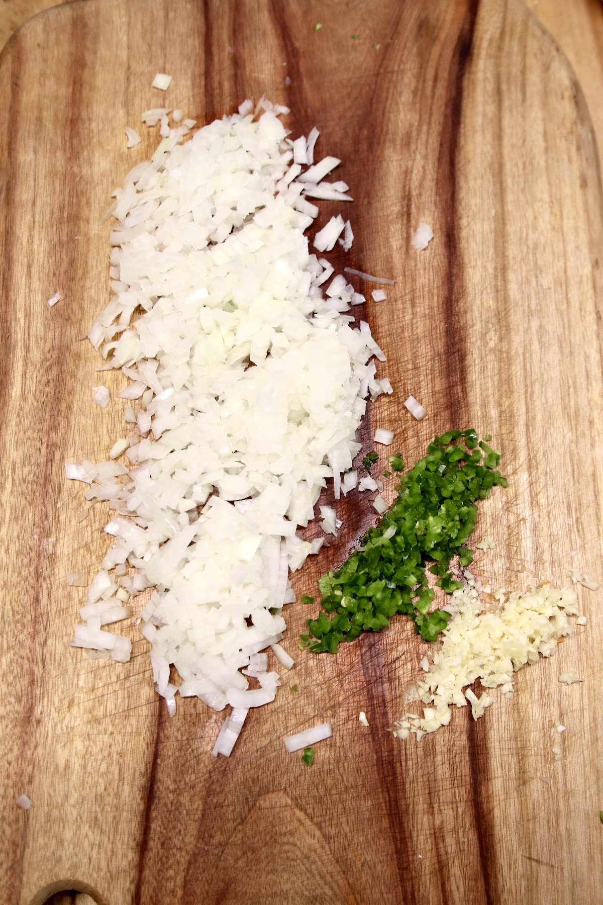cutting board with diced onion, jalapeno and minced garlic