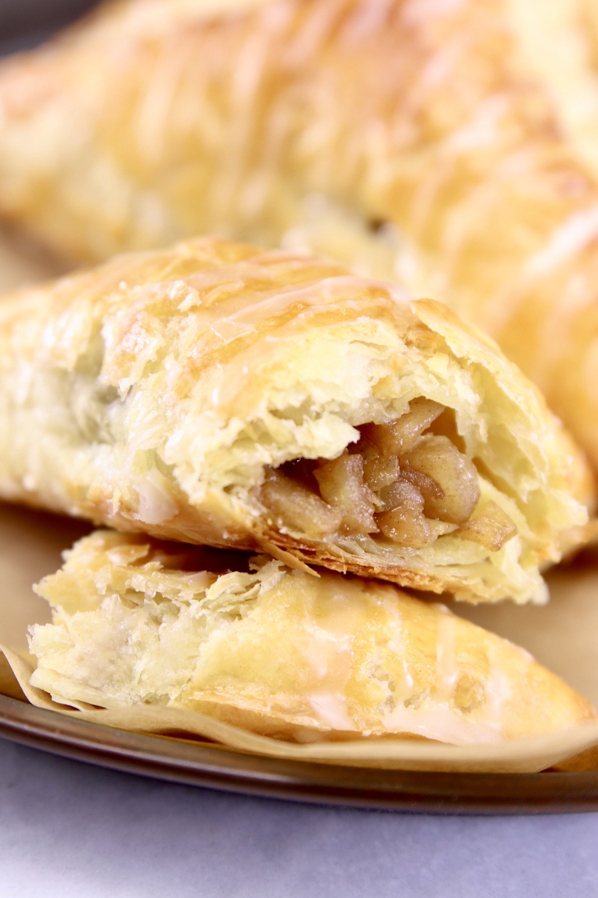 closeup of puff pastry apple turnovers, filling showing on one