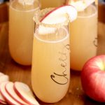 champagne glasses with apple cider mimosas - apple slice and caramel/sugar rim garnish