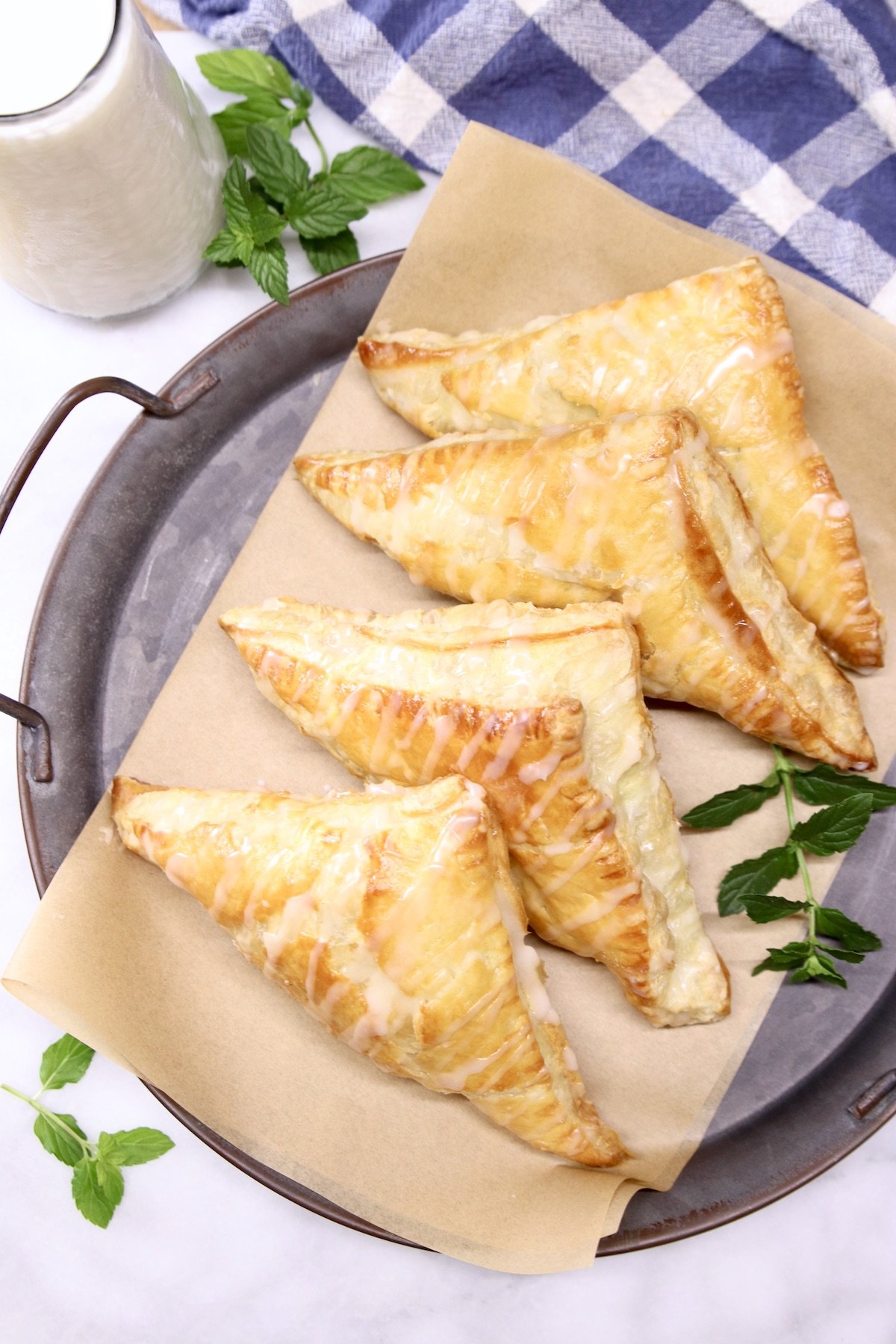 4 apple turnovers on a tray with mint garnish
