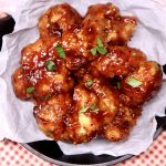bbq boneless wings in a cast iron dish, lined with white parchment