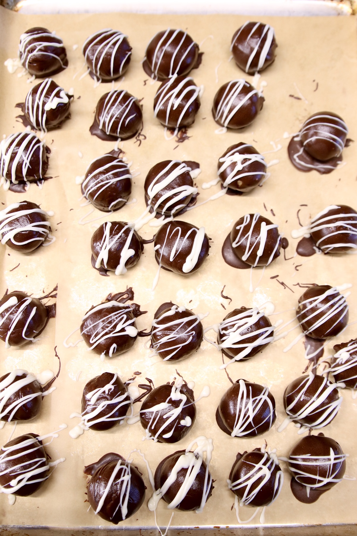 white chocolate drizzle over chocolate peanut butter balls