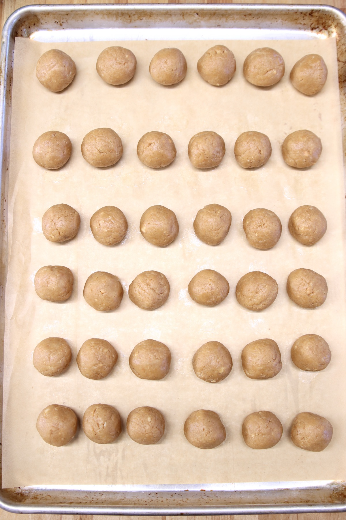 peanut butter balls on a sheet pan with parchment paper