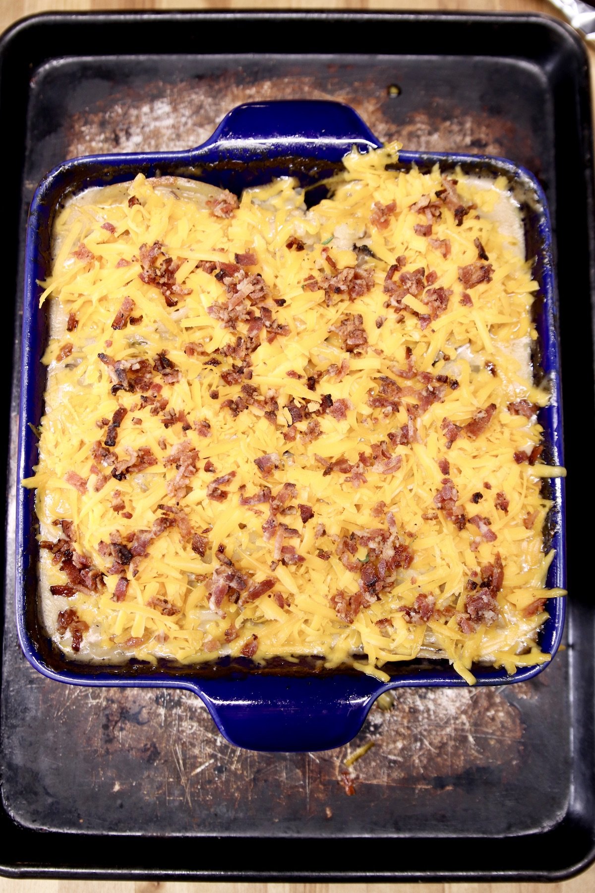 potato casserole topped with shredded cheese and bacon