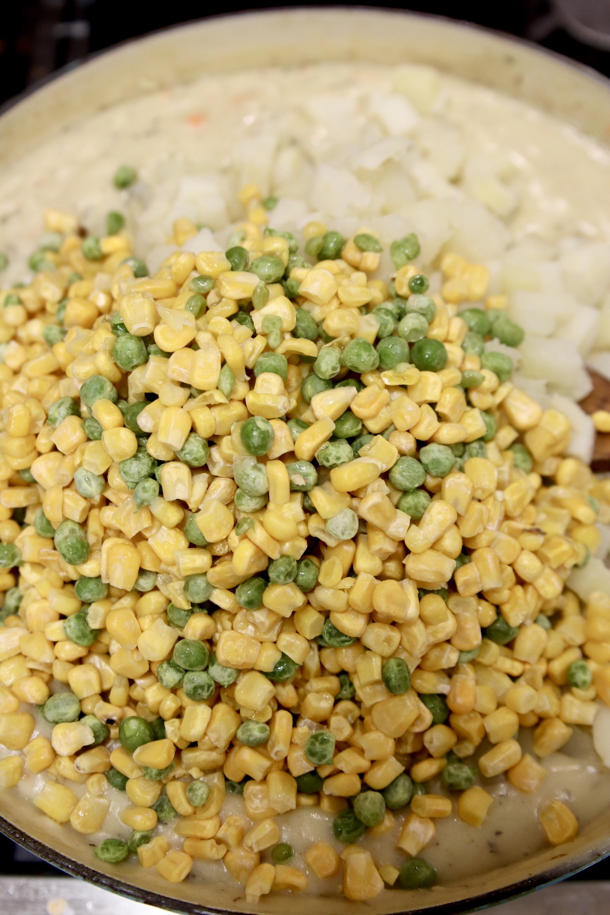 adding corn and peas to chicken pot pie filling