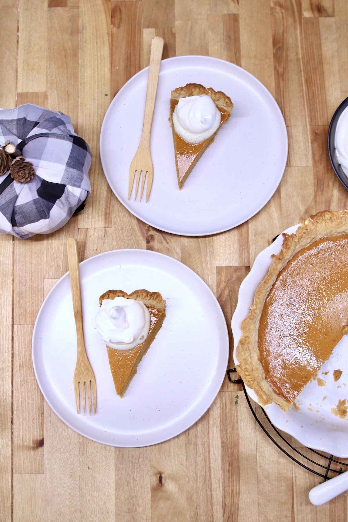 2 plates of pumpkin pie slices with cool whip - overhead view