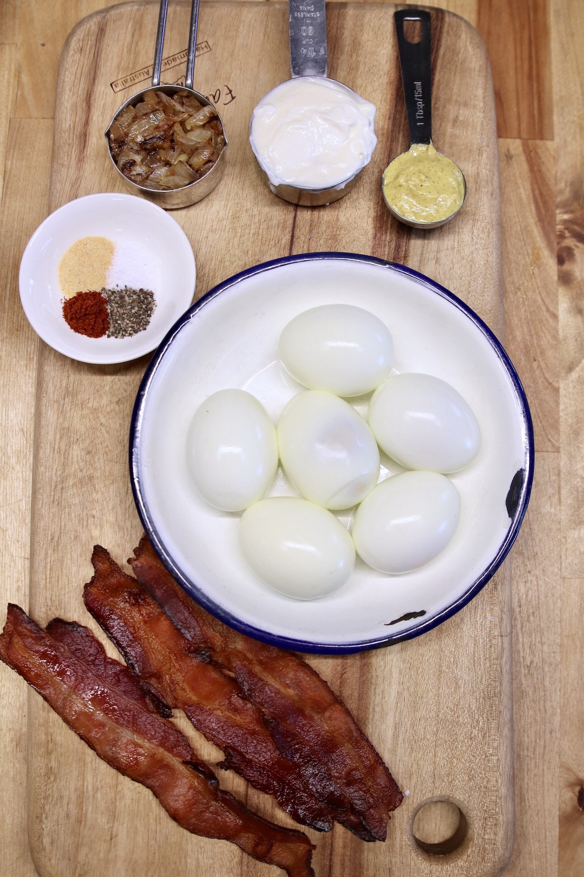 ingredients for bacon deviled eggs on a cutting board