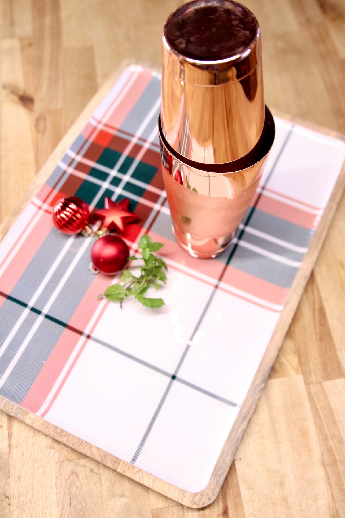 copper cocktail shaker on a plaid tray