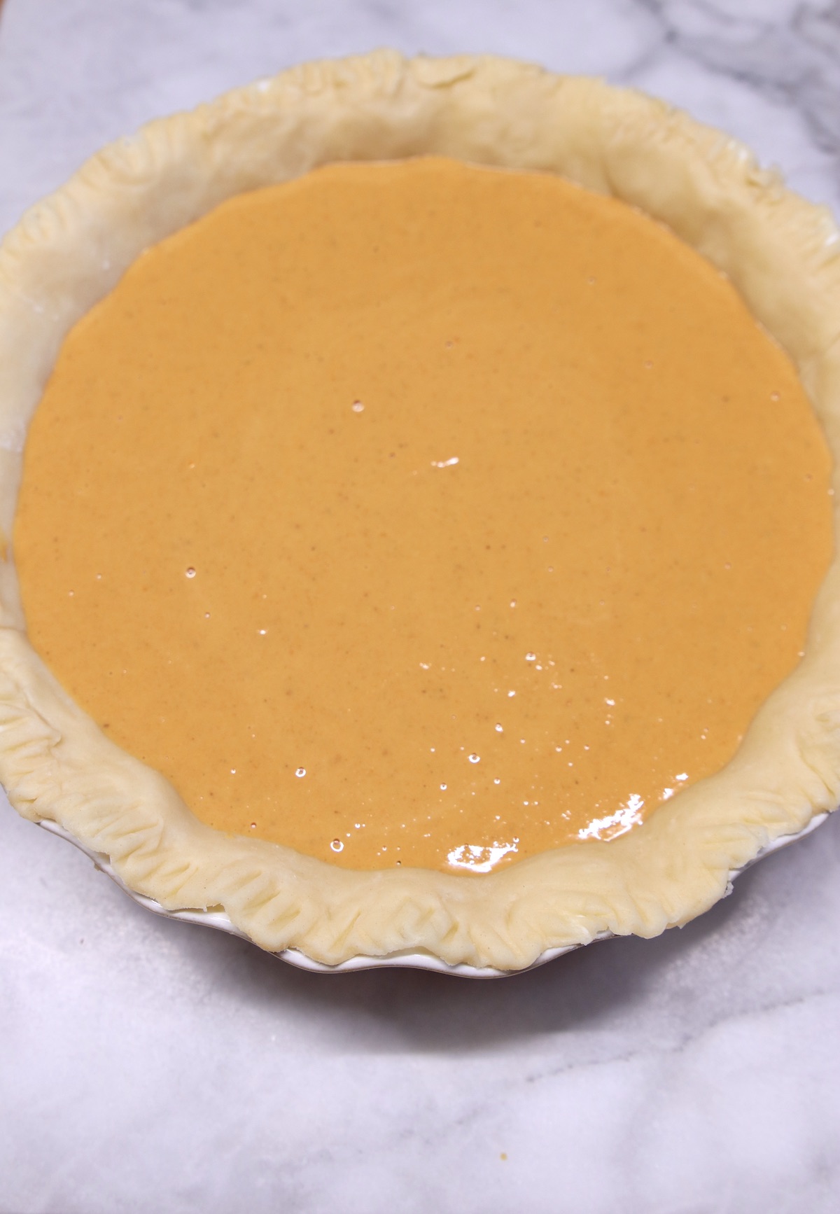 pie crust filled with pumpkin pie filling