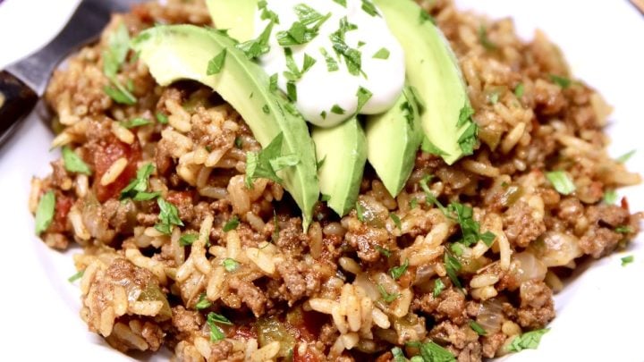 Spanish Rice with Ground Beef topped with sour cream, avocado slices and cilantro