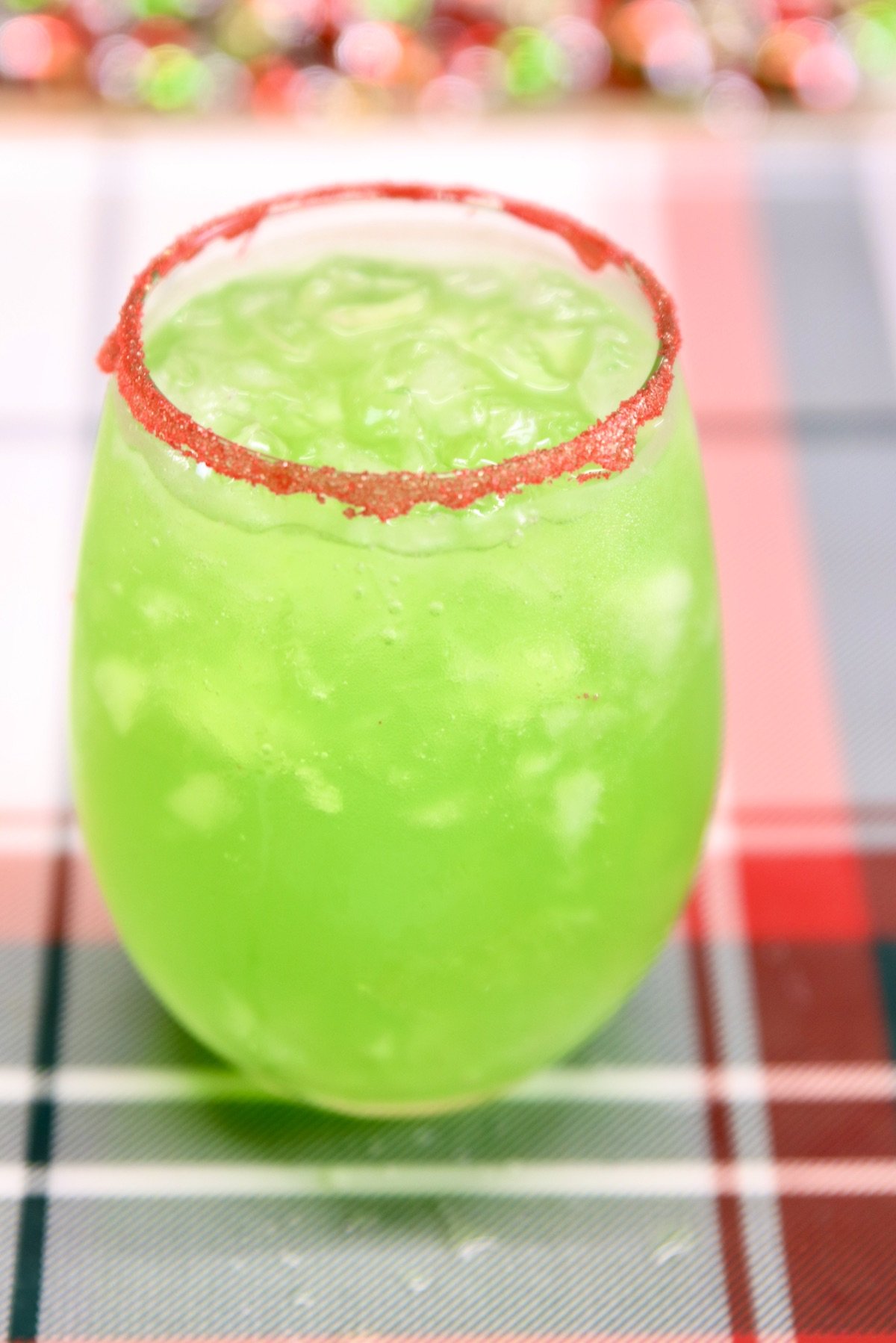 closeup of green punch with red sugar rim in a wine glass