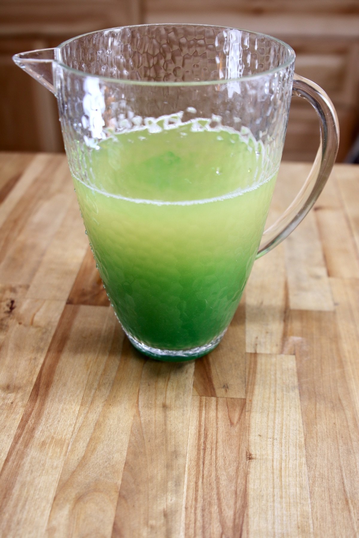 making green punch for Christmas in a pitcher