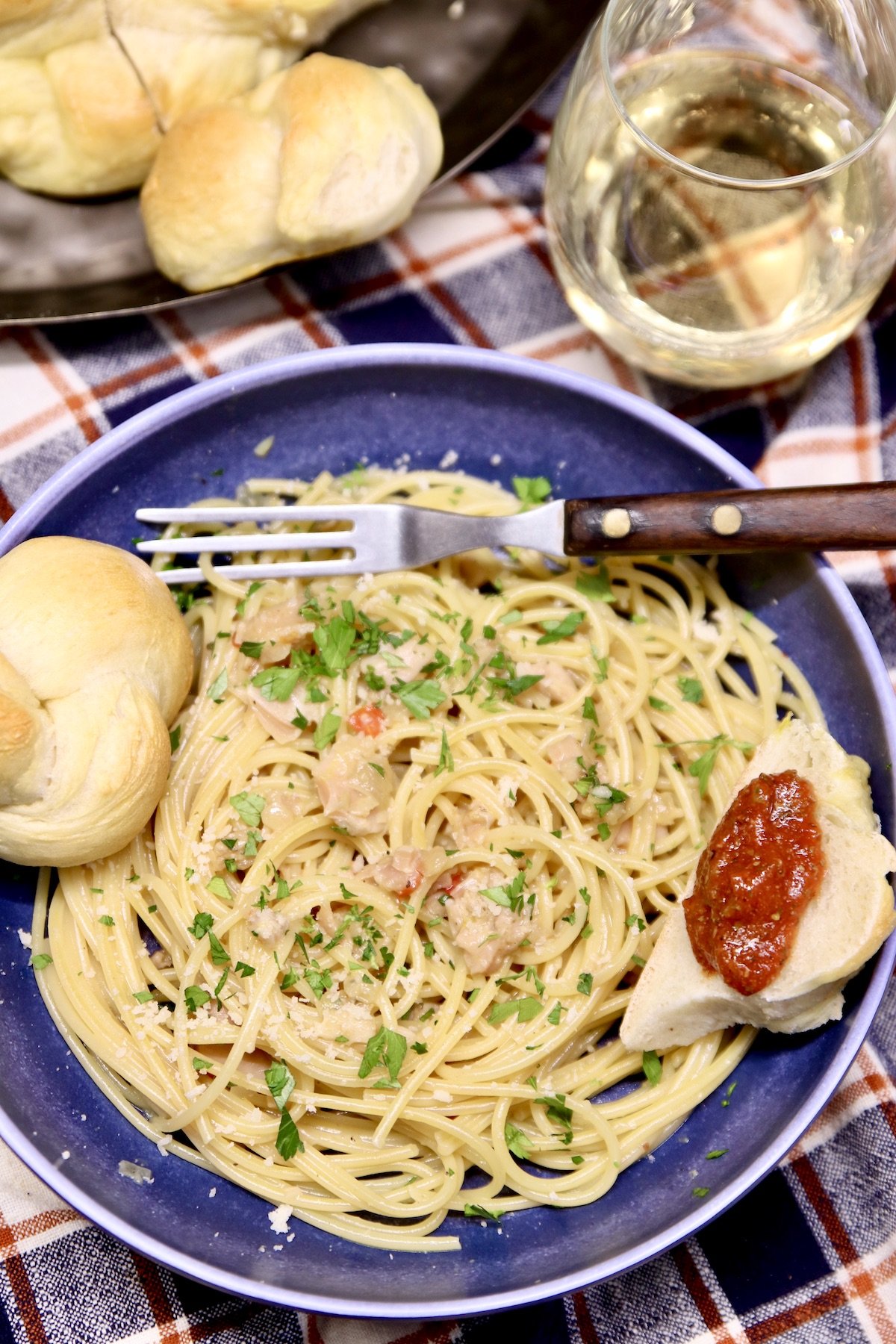 pasta with clam sauce in a blue bowl with bread 