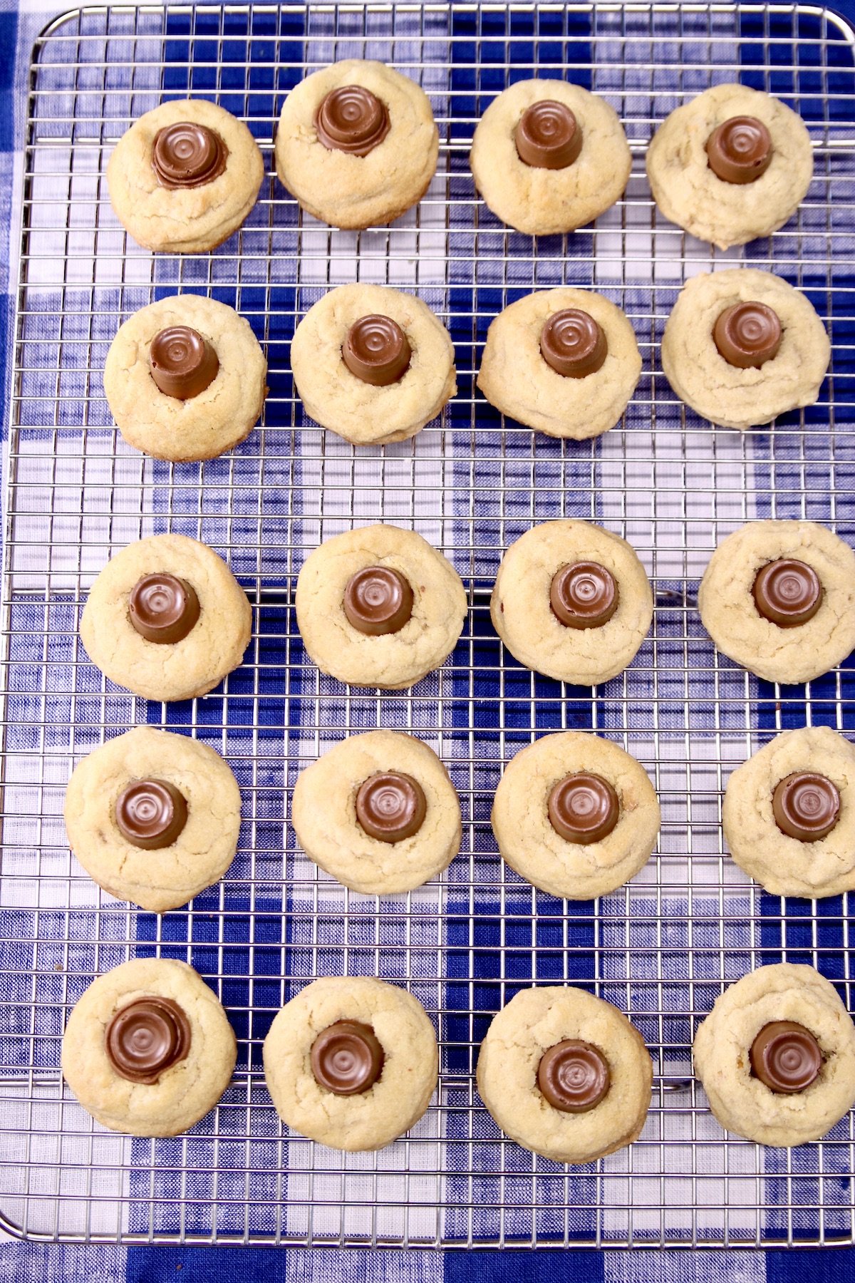 rolo peanut butter cookies on a wire rack over blue check towel