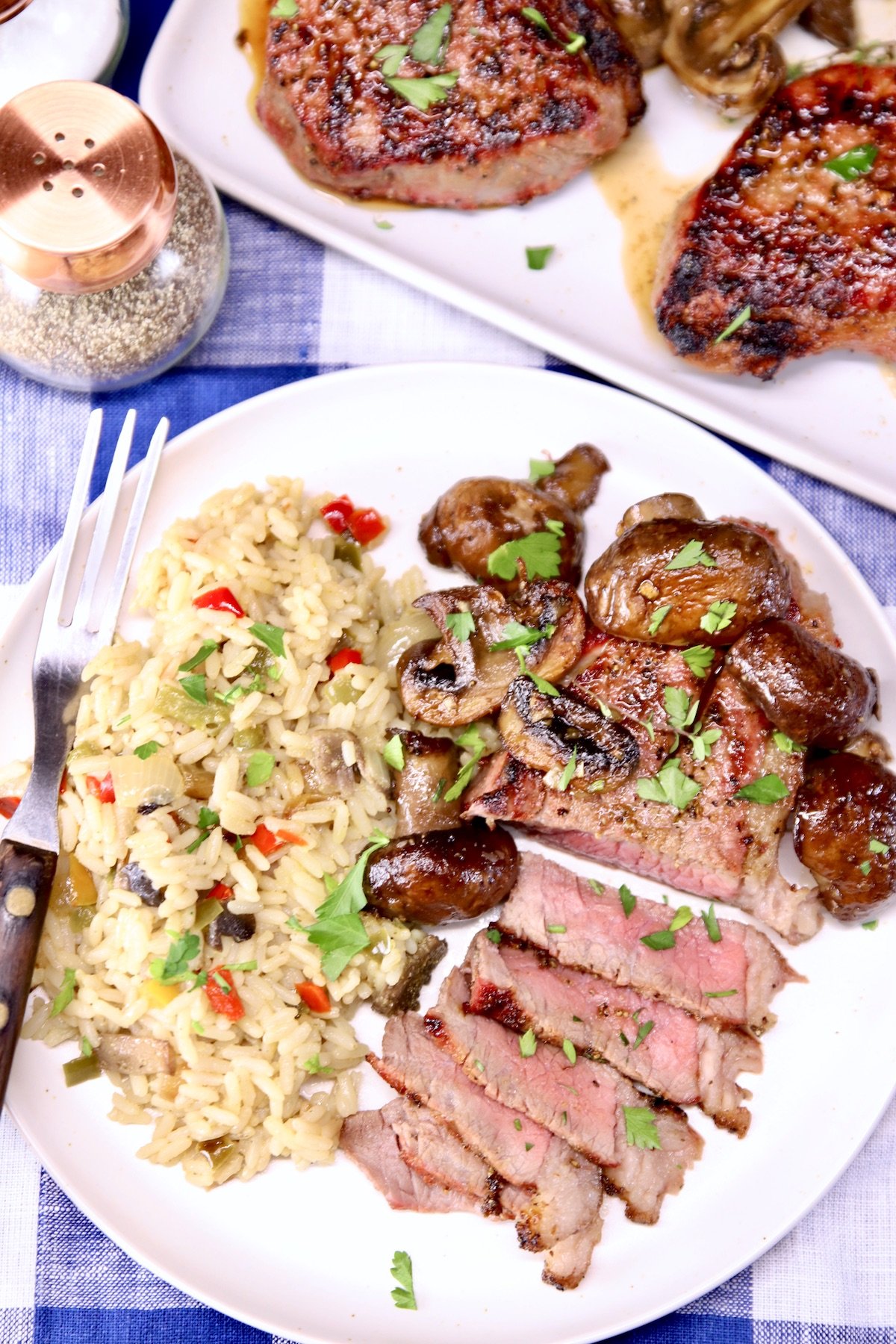 overhead of plate: rice pilaf, steak, sliced with mushrooms