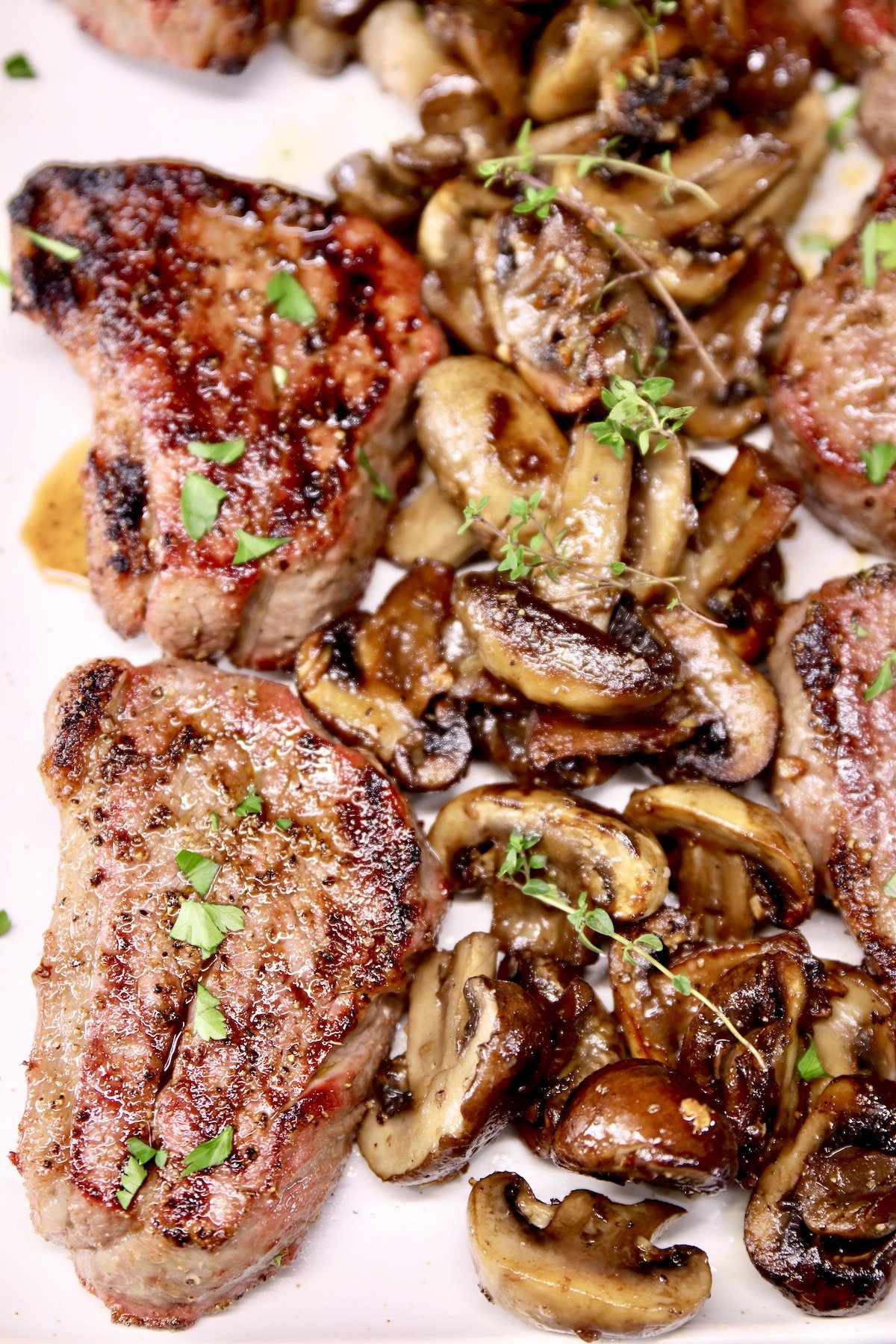close up of platter of grilled steaks with mushrooms