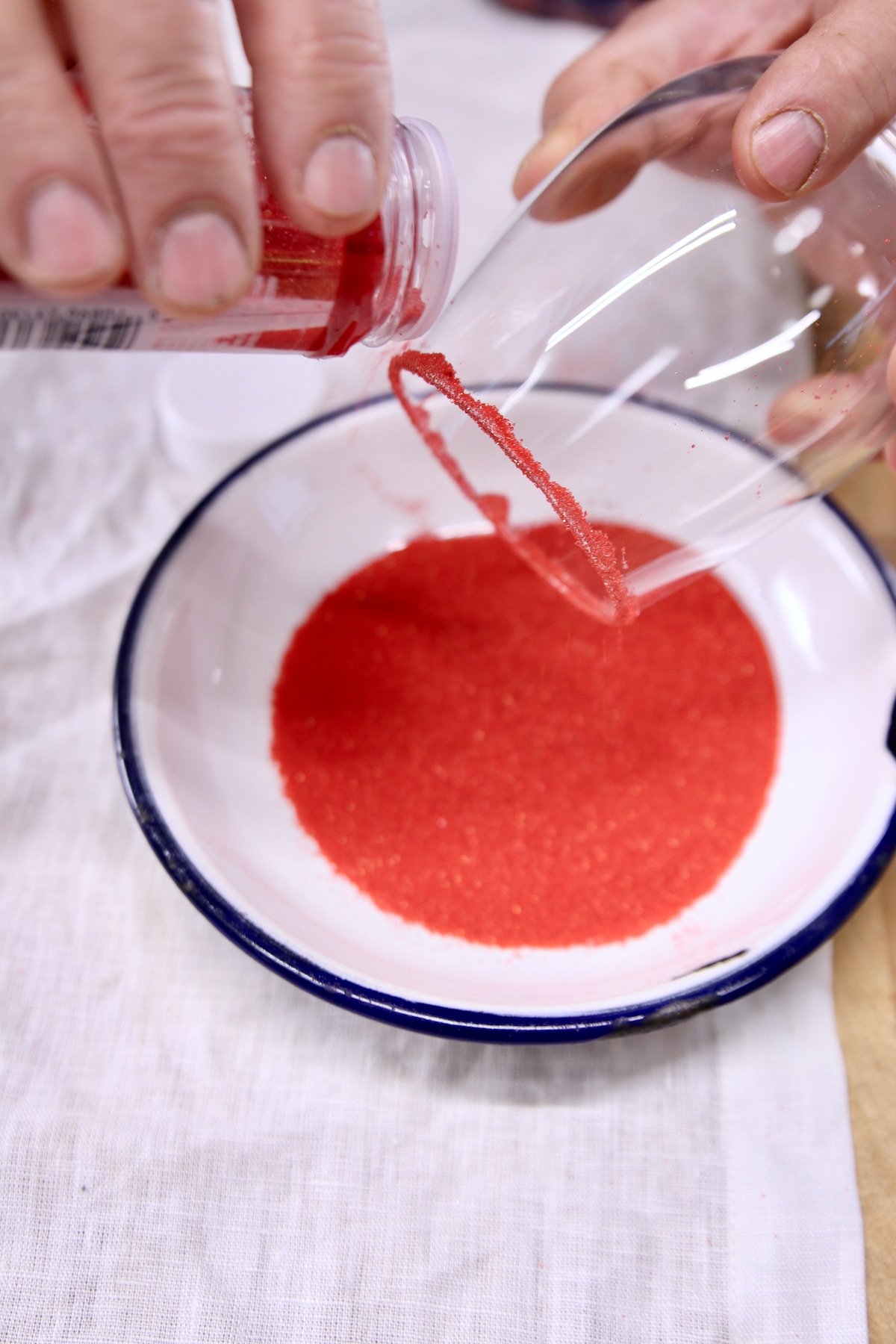 red sugar pouring over cocktail glass rim