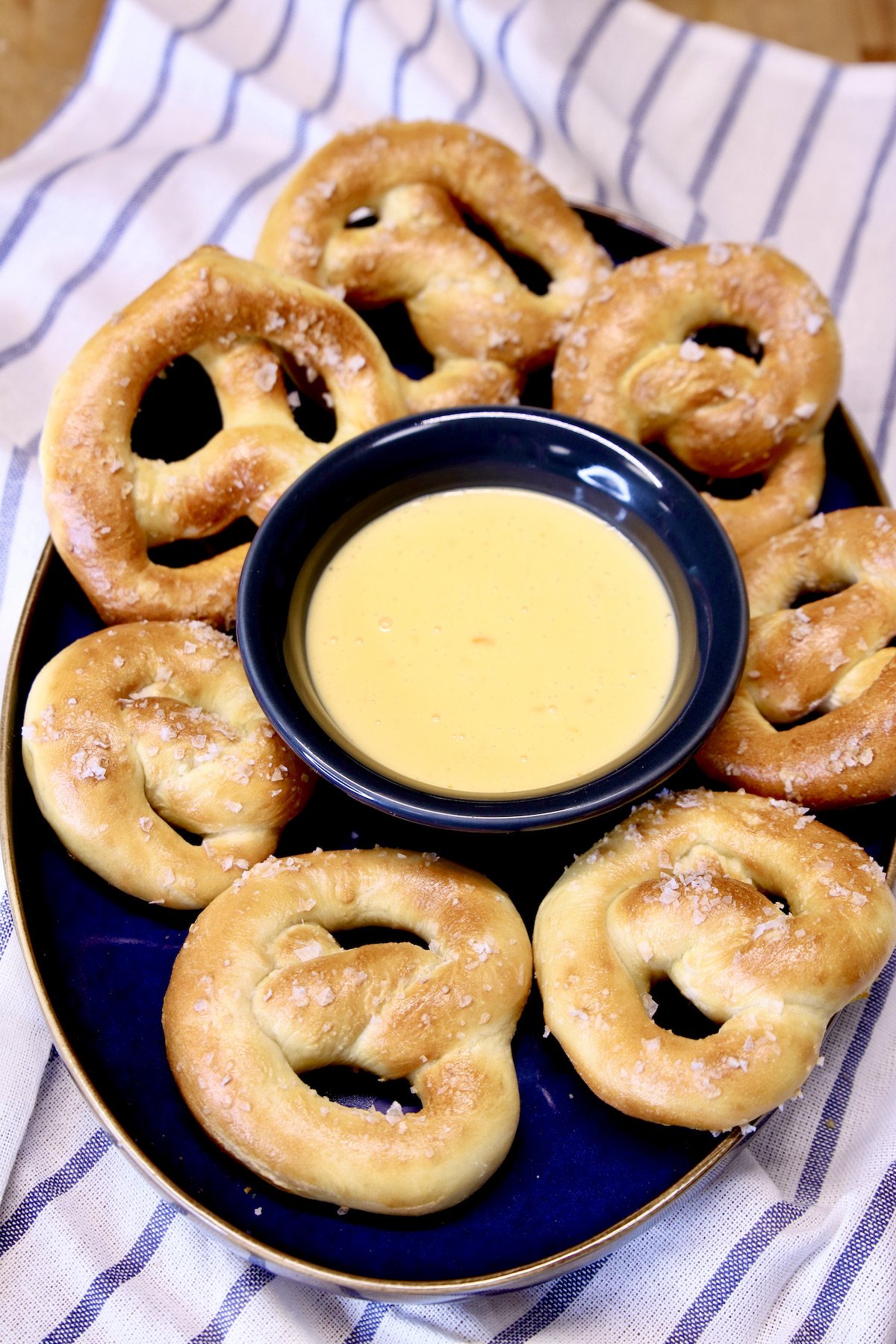 platter of soft pretzels with cheese sauce in center