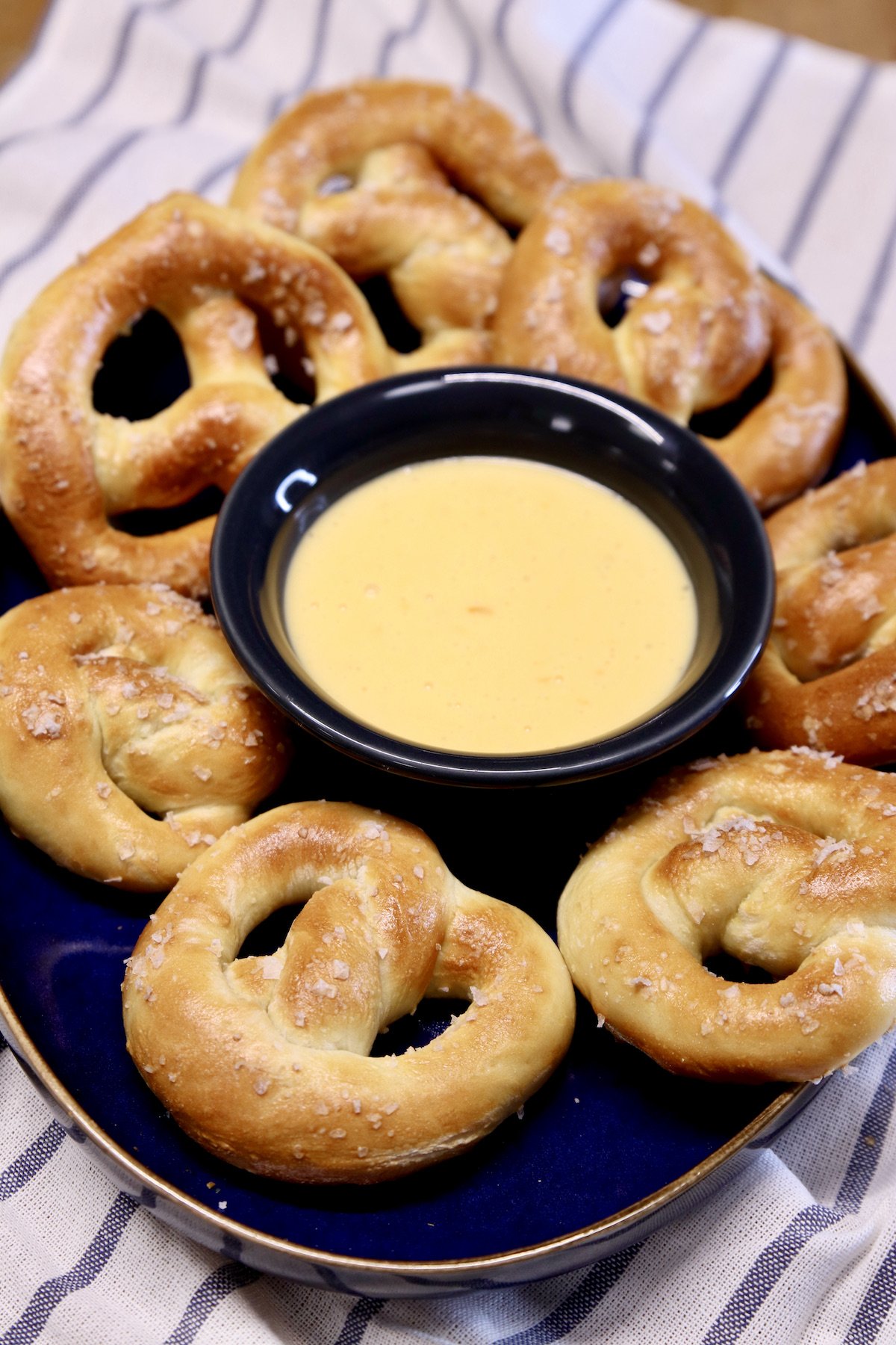 soft pretzels on a platter with cheese sauce