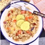 bowl of bacon cheeseburger rice in a bowl, topped with tomatoes and pickles