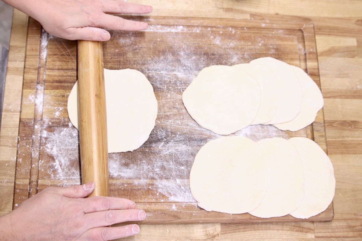 rolling pizza dough into circles for calzone