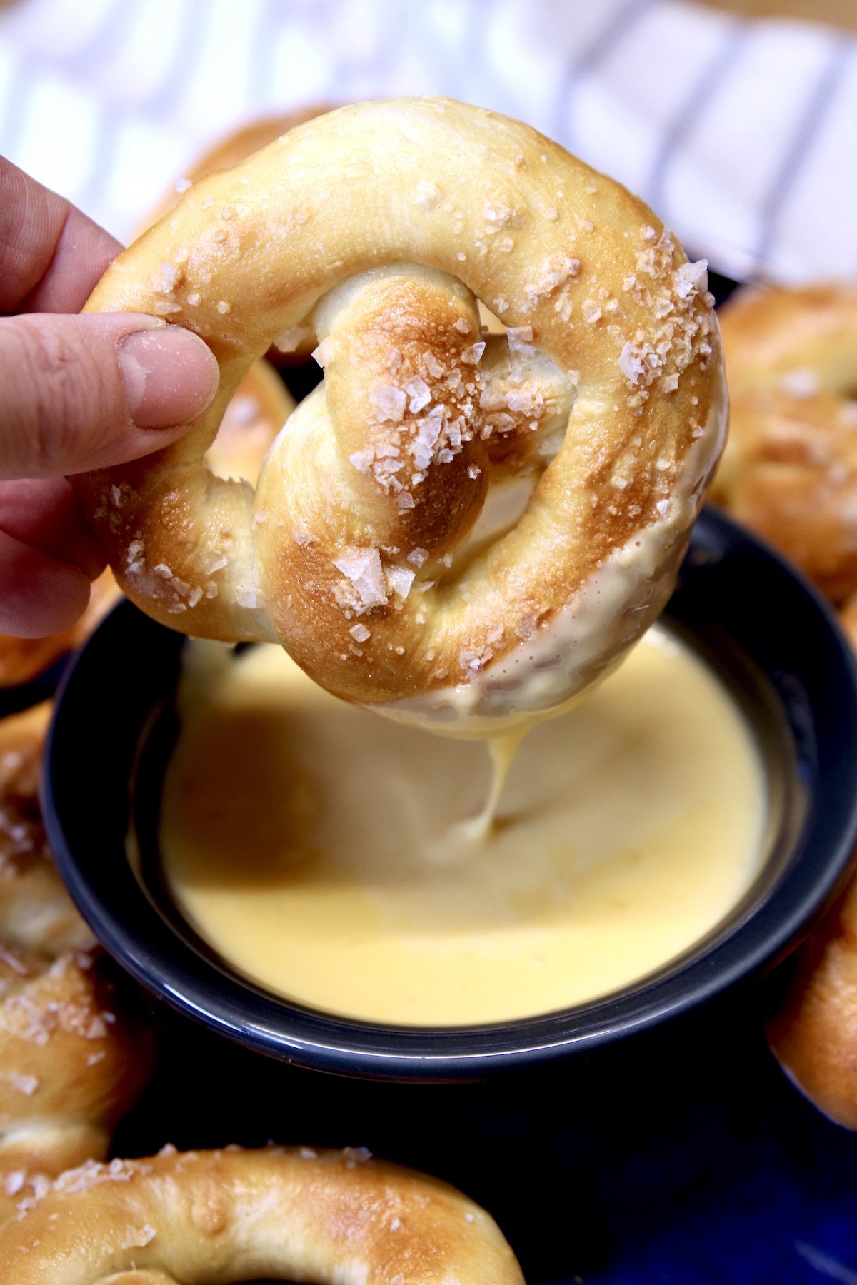Soft pretzel dipping into cheese sauce
