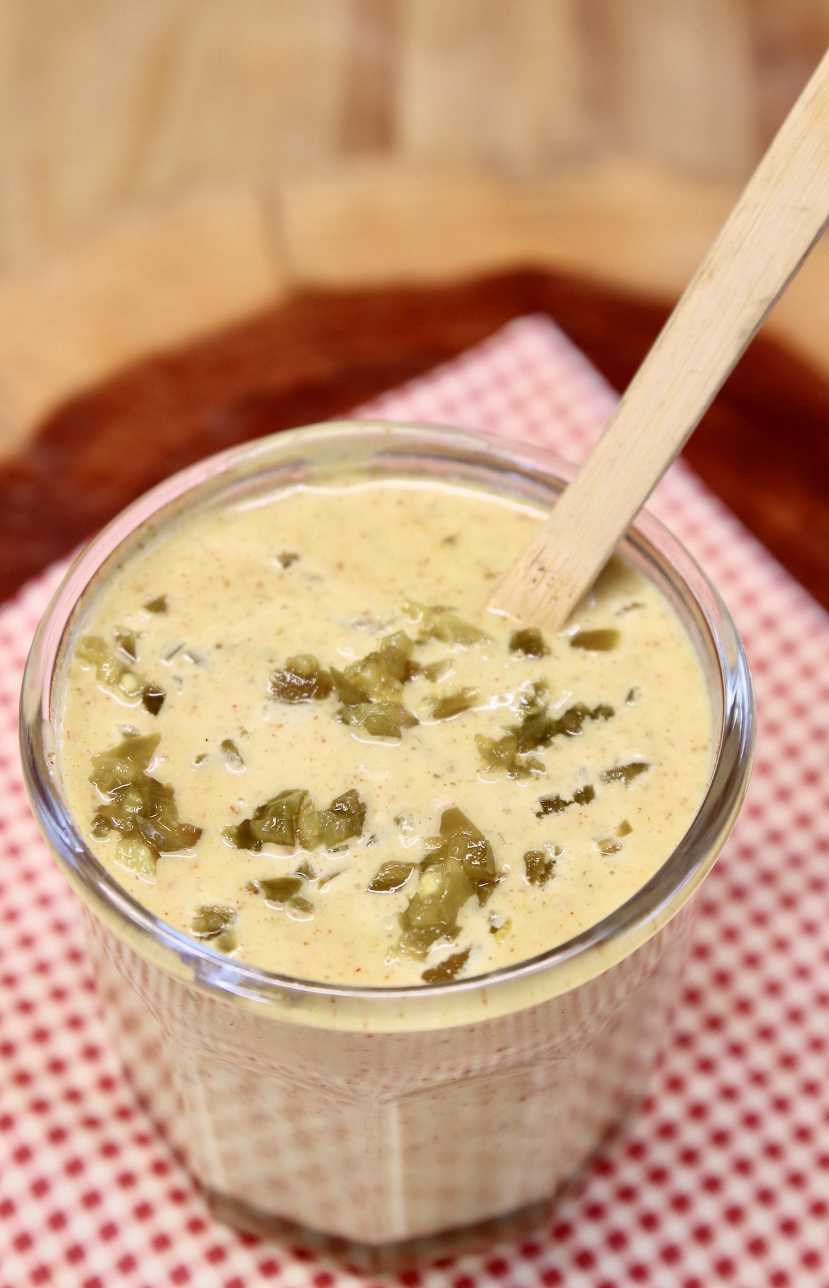 Jalapeno Honey Mustard in a jar with a wood spoon