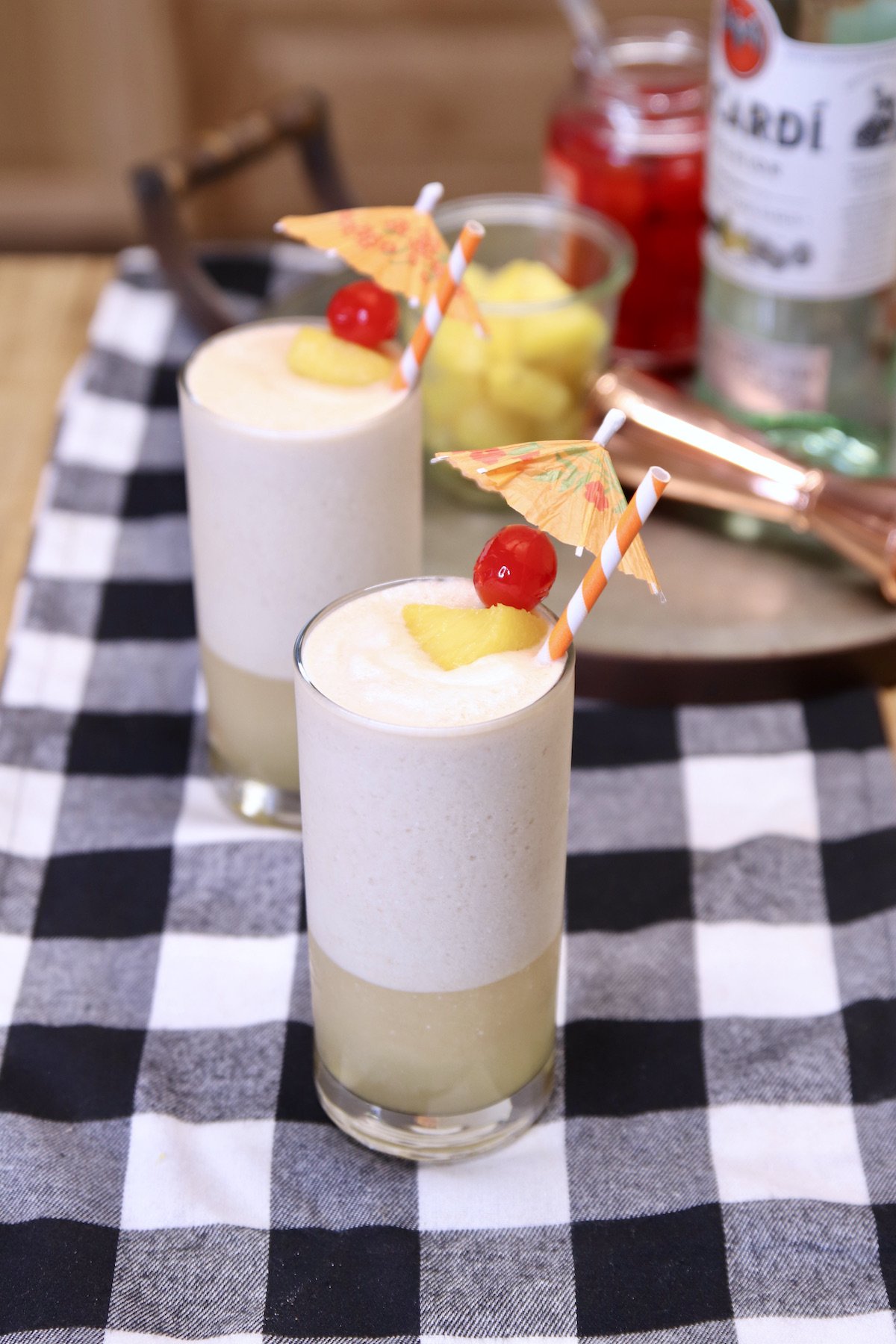 rocket fuel pineapple and coconut cocktails in 2 glasses with cherry/pineapple garnish.