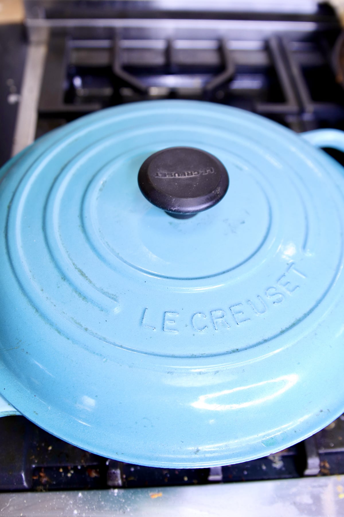 covered blue braiser pan on a stove.
