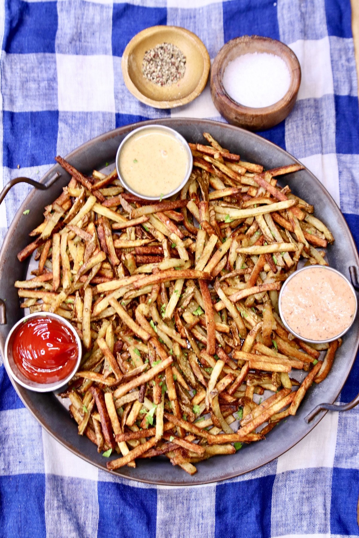 overhead view of platter of fries with 3 dipping sauces. 