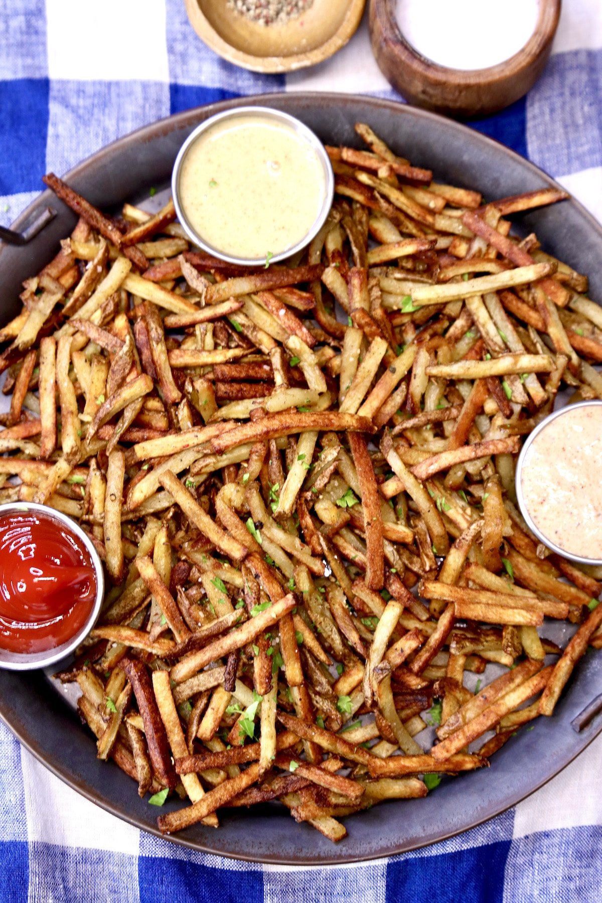 duck fat oven fries on a tray with 3 dipping sauces.