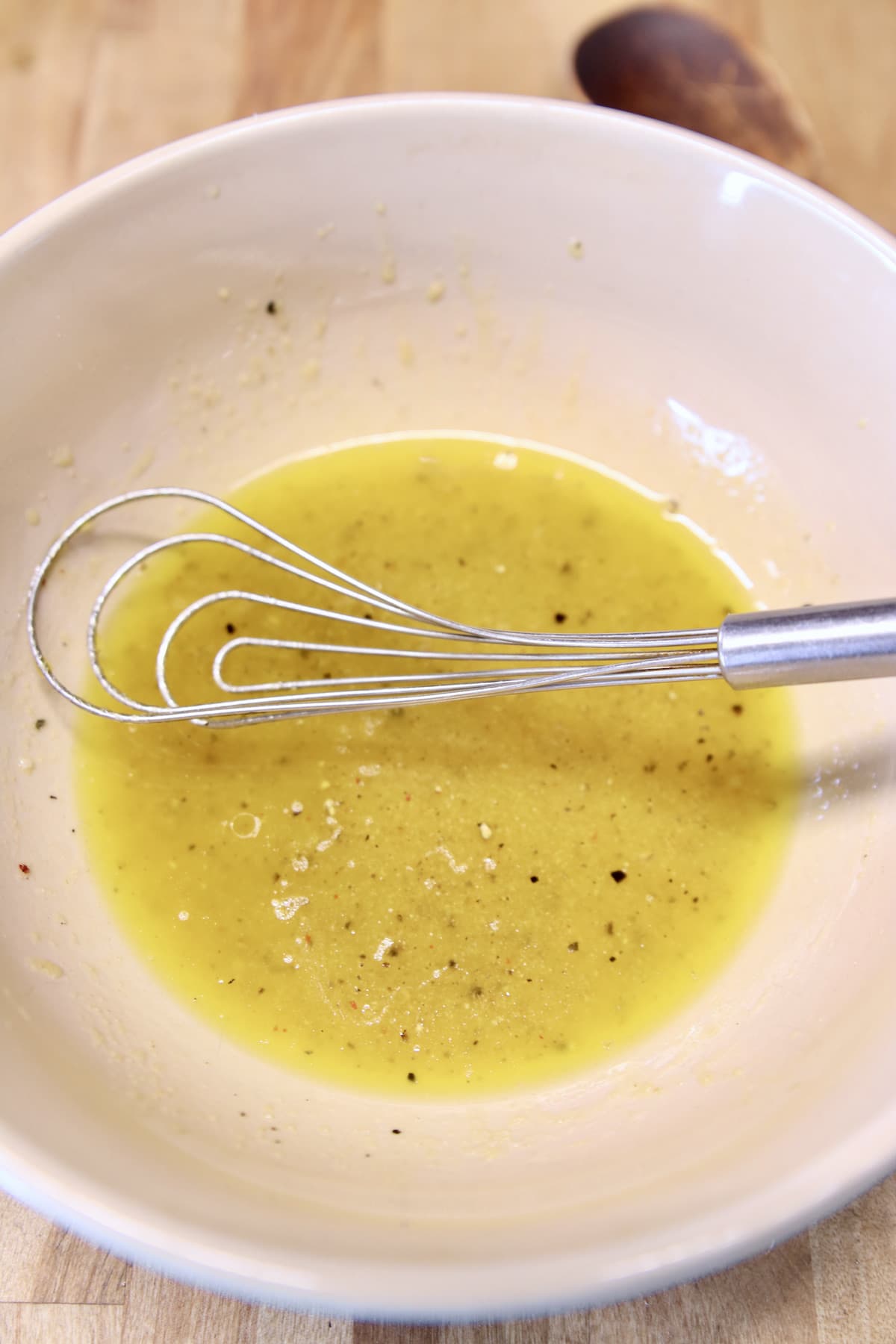 bowl with vinegar dressing and a whisk.