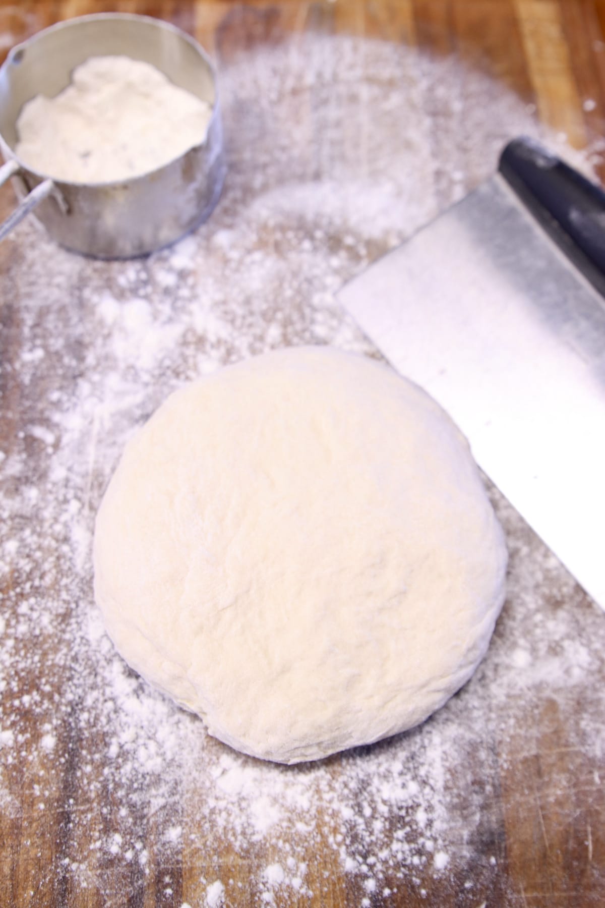 pretzel dough in a round on a floured cutting board