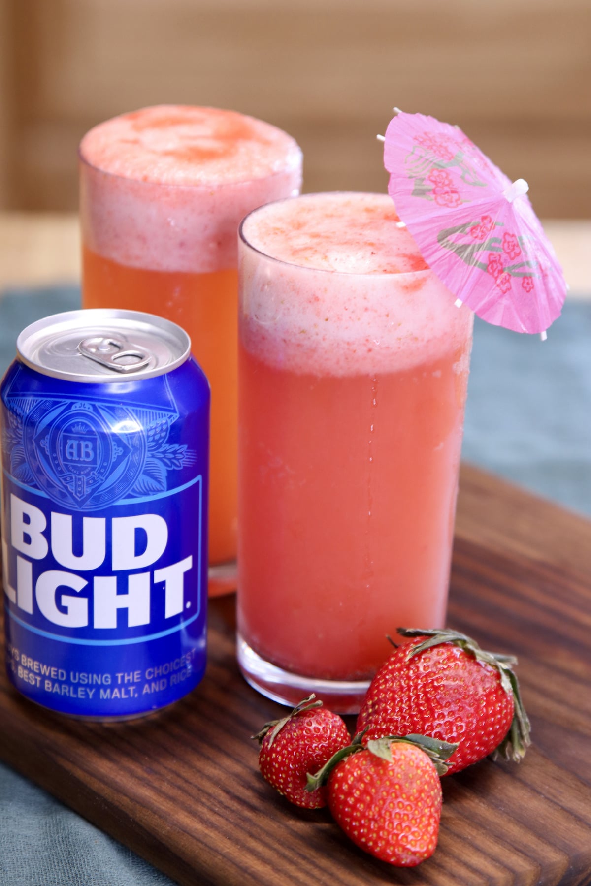 bud light beer with 2 glasses of strawberry shandy cocktails.