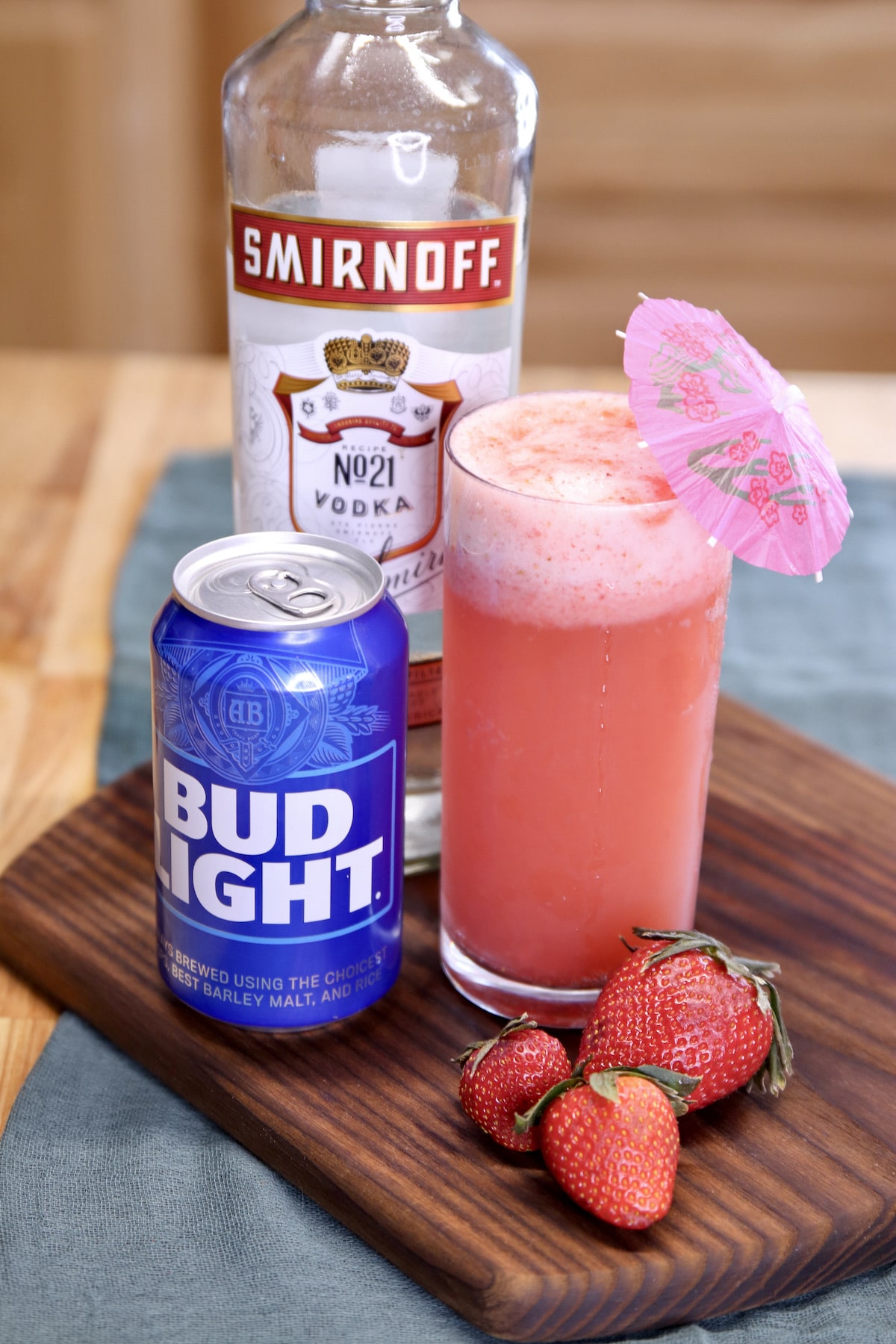strawberry shandy cocktail with a can of bud light beer and bottle of smirnoff vodka.
