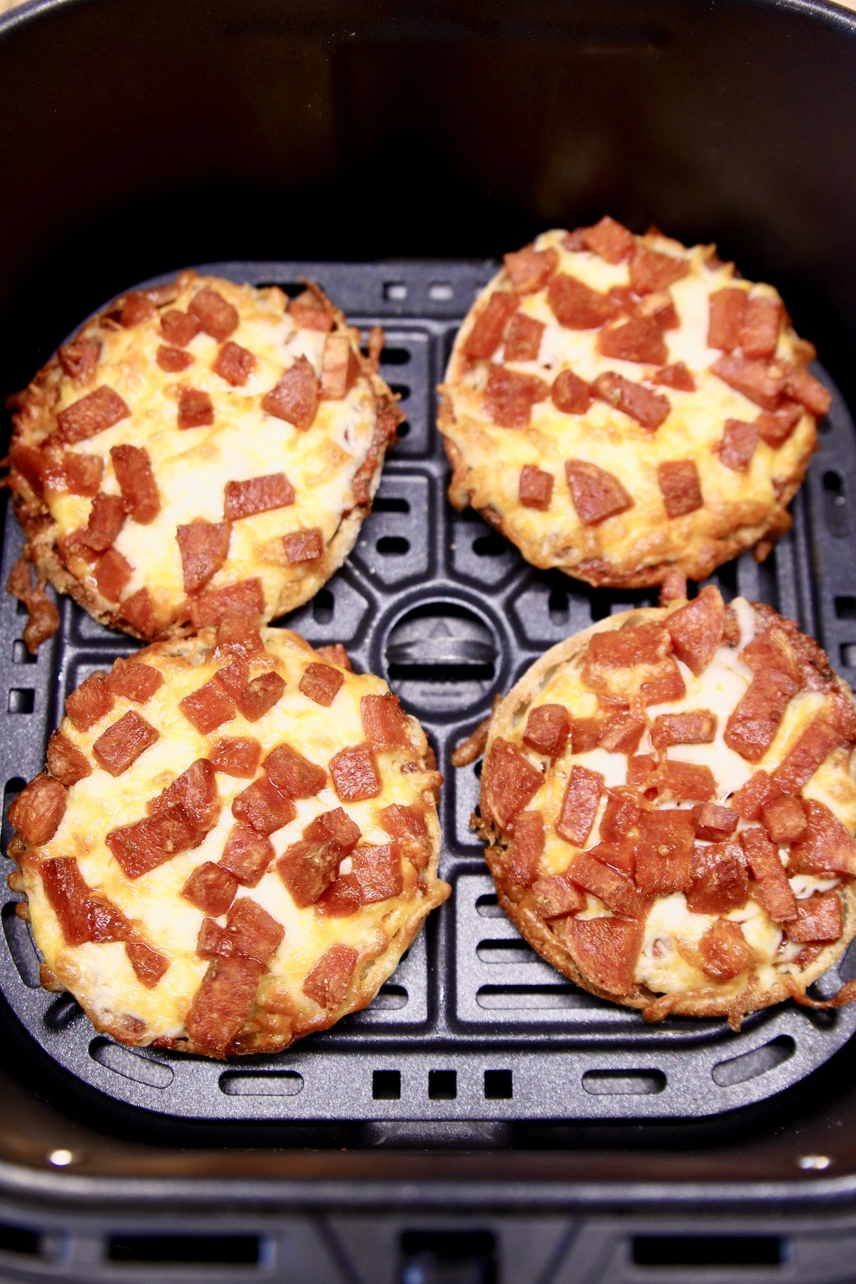 Air fryer with 4 mini pizzas.